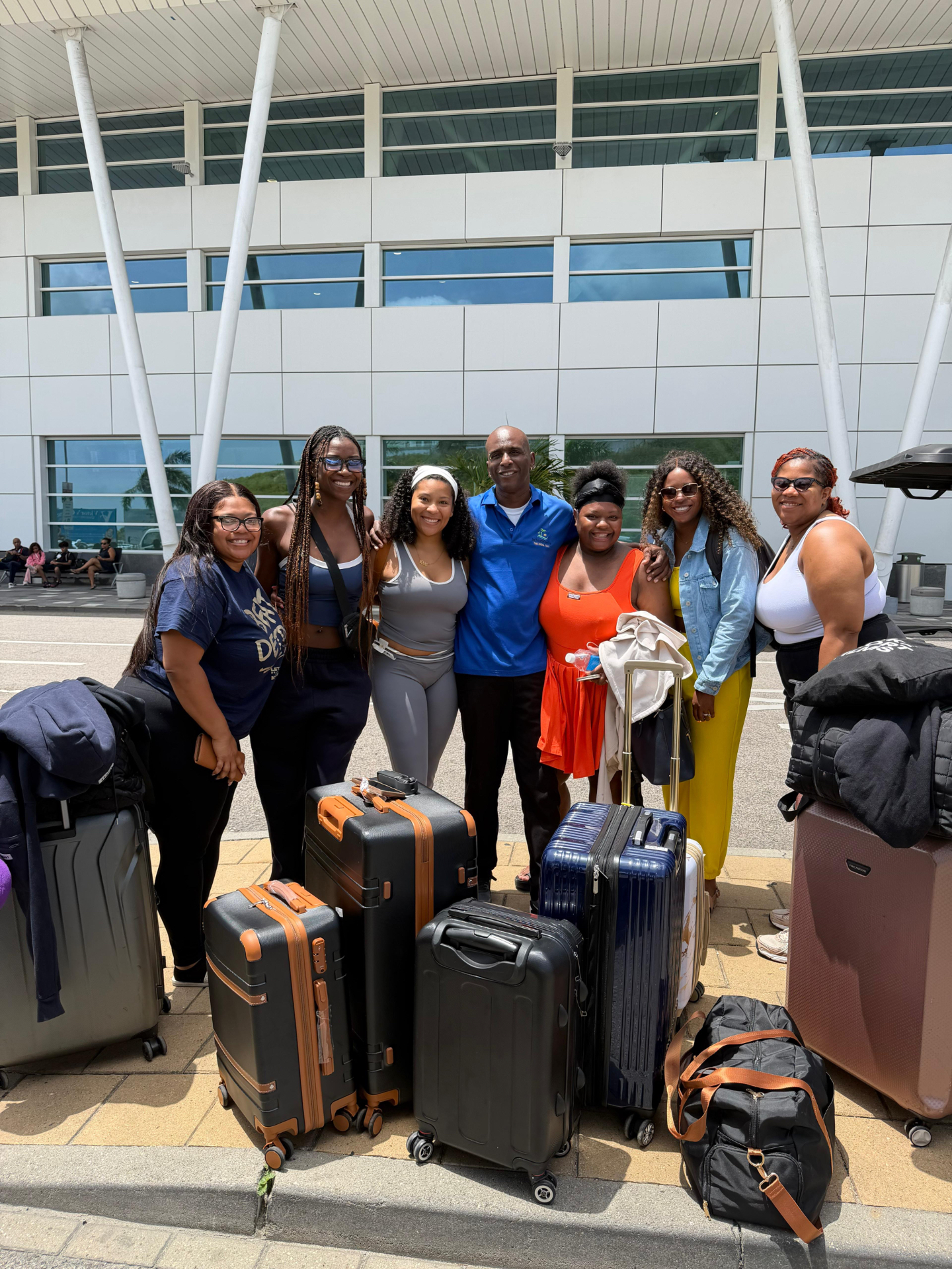 Andy welcoming a group of travelers with their luggage at Princess Juliana International Airport, Sint Maarten